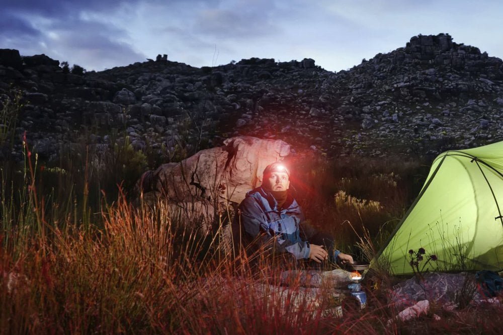 Headlamp with red light mode active in forest red light mode headlamp