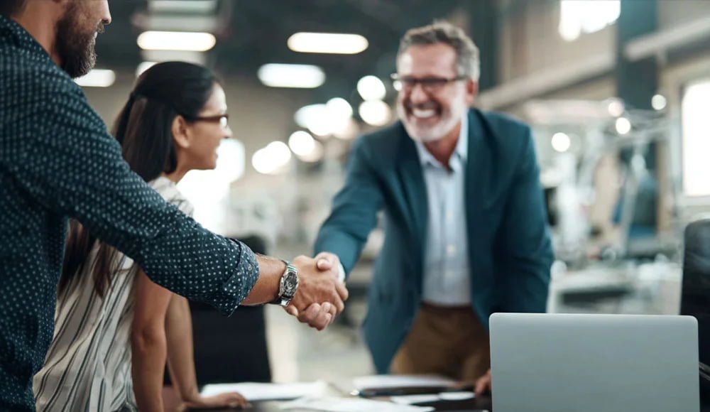 business handshake in factory